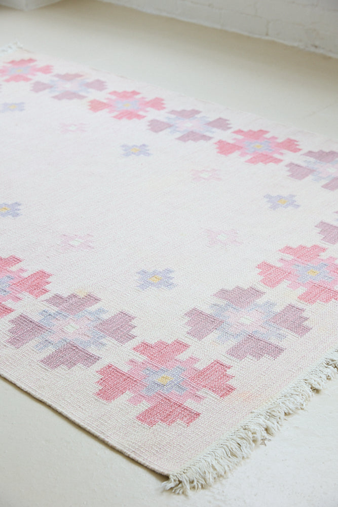 Ola is an original 1960s röllakan flatweave rug, featuring a pretty geometric floral pattern. The rug is signed ILS.