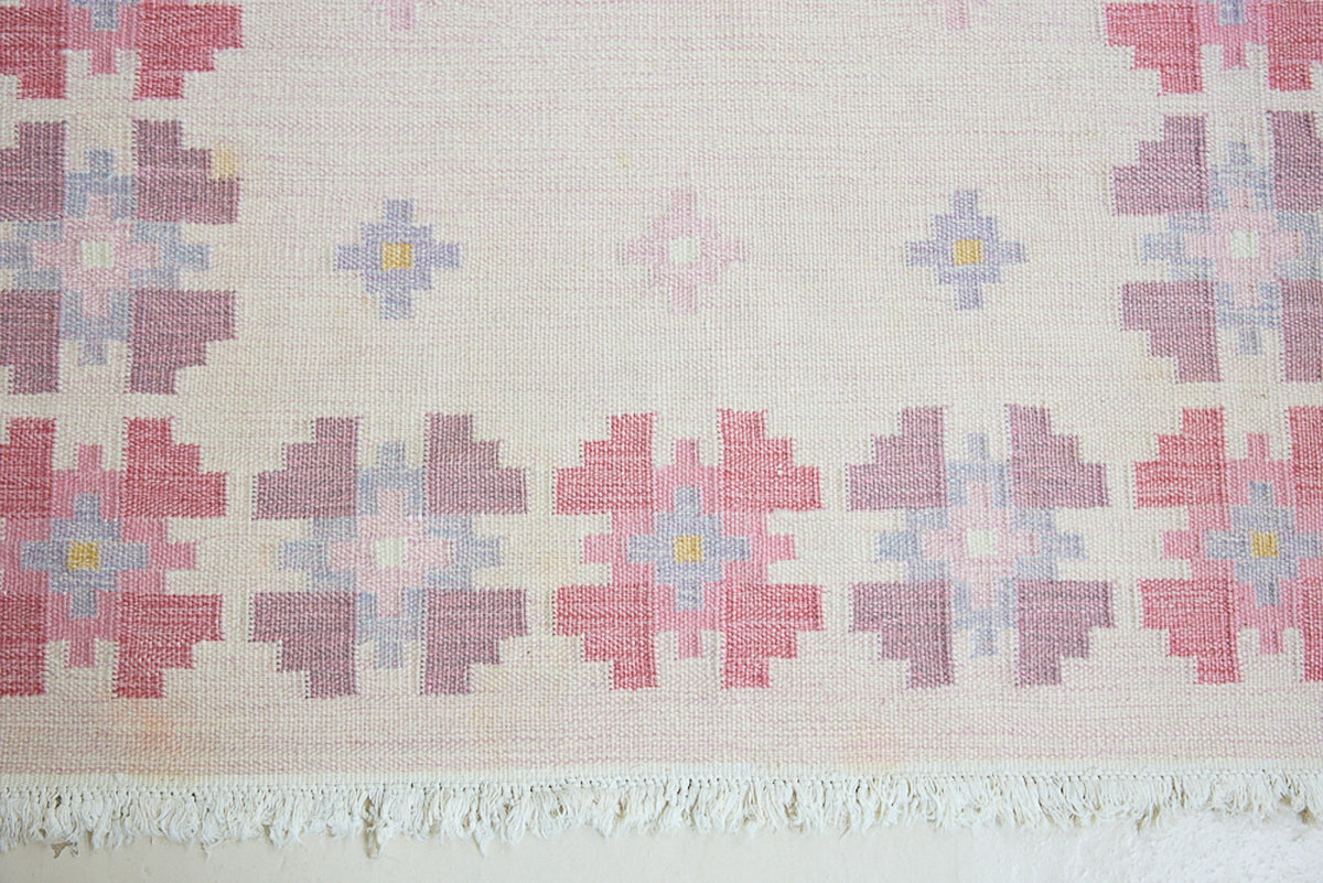 Ola is an original 1960s röllakan flatweave rug, featuring a pretty geometric floral pattern. The rug is signed ILS.