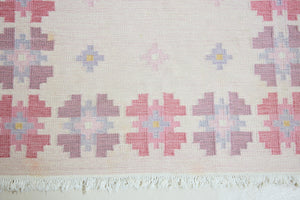 Ola is an original 1960s röllakan flatweave rug, featuring a pretty geometric floral pattern. The rug is signed ILS.