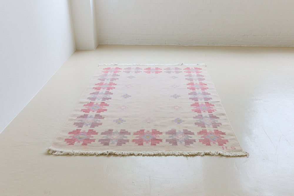 Ola is an original 1960s röllakan flatweave, featuring a pretty geometric floral pattern. The rug is signed ILS.