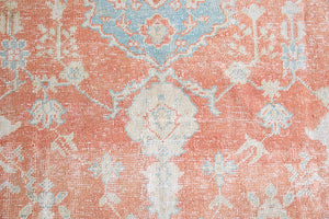 An antique Turkish Oushak rug. Perdita features a large-scale, open medallion pattern, flowing botanical motifs and a generous field space set against a blue and terracotta ground.