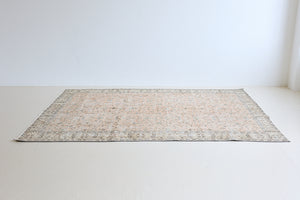 Rosh is a vintage wool rug handwoven in Turkey approximately 80 years ago. The soft terracotta field is decorated with an all floral scrolls pattern framed by a subtle contrasting taupe boarder.