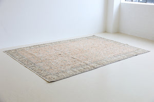 Rosh is a vintage wool rug handwoven in Turkey approximately 80 years ago. The soft terracotta field is decorated with an all floral scrolls pattern framed by a subtle contrasting taupe boarder.