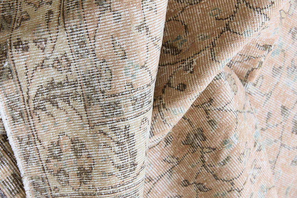 Rosh is a vintage wool rug handwoven in Turkey approximately 80 years ago. The soft terracotta field is decorated with an all floral scrolls pattern framed by a subtle contrasting taupe boarder.