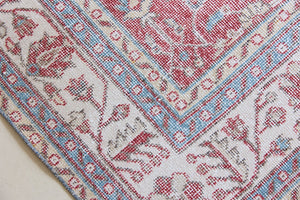 Teresa is a vintage rug handwoven in Turkey approximately 80 years ago. The warm red field and soft blue and beige border are intertwined with an all over flowering vine pattern.