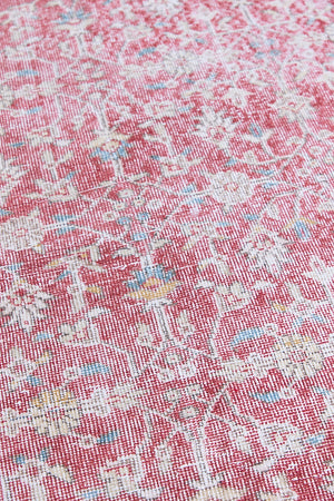 Teresa is a vintage rug handwoven in Turkey approximately 80 years ago. The warm red field and soft blue and beige border are intertwined with an all over flowering vine pattern.