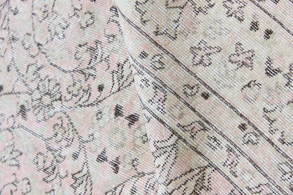 Josie is a vintage wool rug handwoven in Turkey approximately 80 years ago. The soft pink field and is decorated with an all floral scrolls pattern framed by a subtle contrasting taupe boarder.