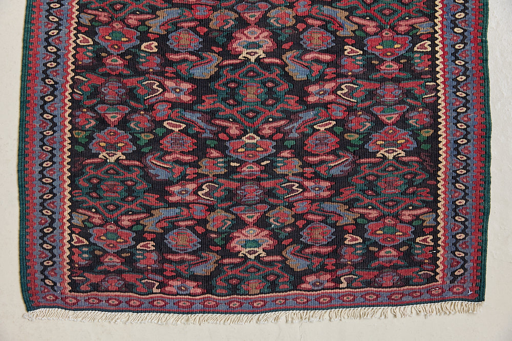 Woven in the Kurdish highlands of northwest Iran, Senneh kilims are distinguished by an exceptional fineness of weave with a tight slit-tapestry construction with a high level of intricacy. Celestine features a decorative all over pattern in pinks, blues and greens on a black field.