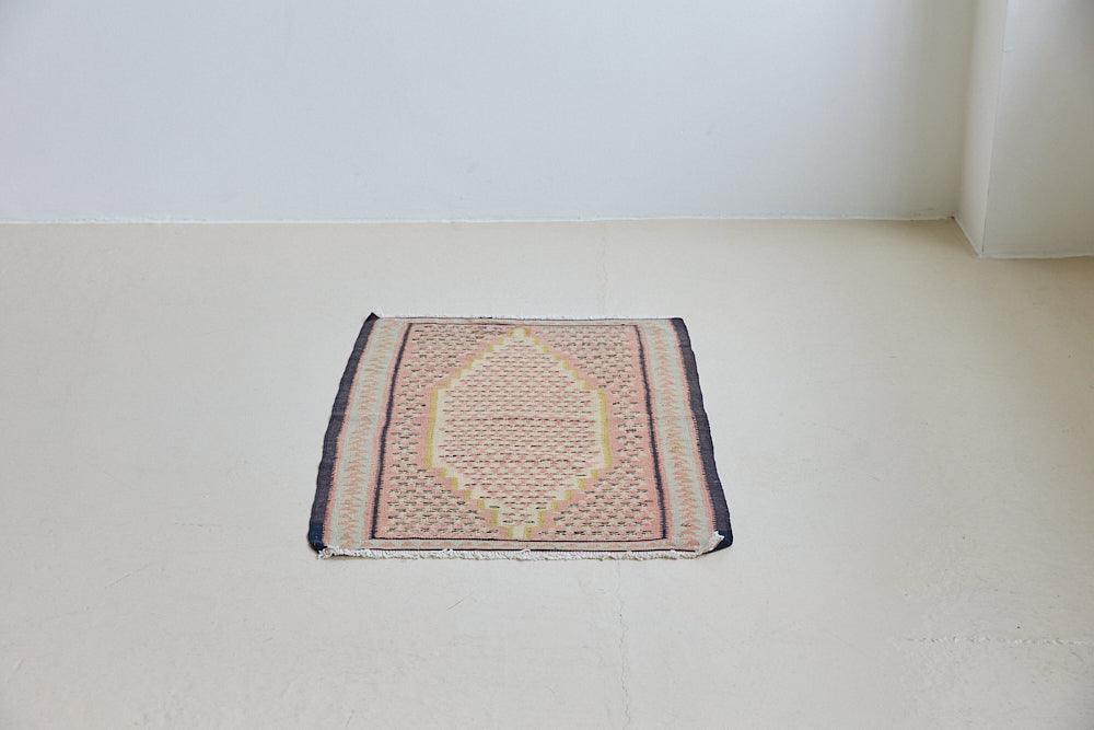 An antique Senneh kilim rug. Lale features a delicate pink and taupe central lozenge medallion on a taupe floral field with contrasting boarder.