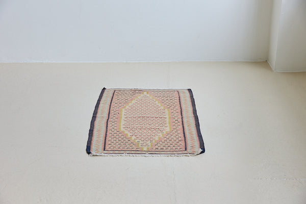 An antique Senneh kilim rug. Lale features a delicate pink and taupe central lozenge medallion on a taupe floral field with contrasting boarder.