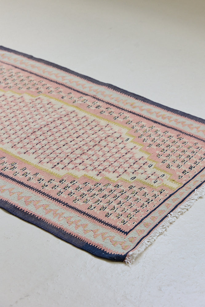 An antique Senneh kilim rug. Lale features a delicate pink and taupe central lozenge medallion on a taupe floral field with contrasting boarder.