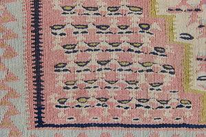 An antique Senneh kilim rug. Lale features a delicate pink and taupe central lozenge medallion on a taupe floral field with contrasting boarder.