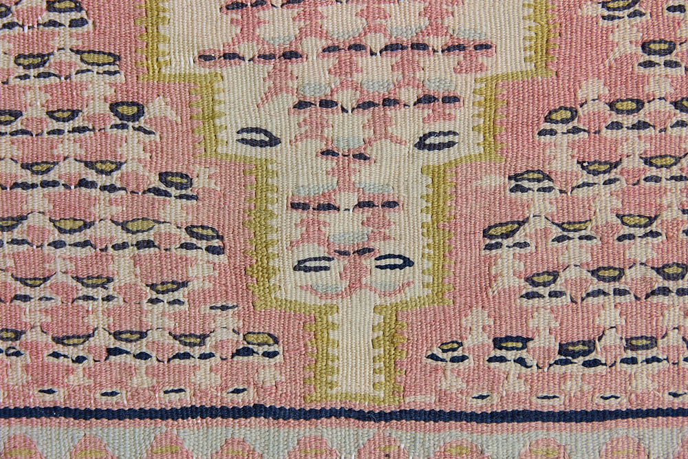 An antique Senneh kilim rug. Lale features a delicate pink and taupe central lozenge medallion on a taupe floral field with contrasting boarder.