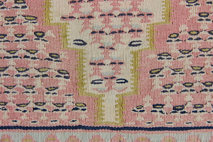 An antique Senneh kilim rug. Lale features a delicate pink and taupe central lozenge medallion on a taupe floral field with contrasting boarder.