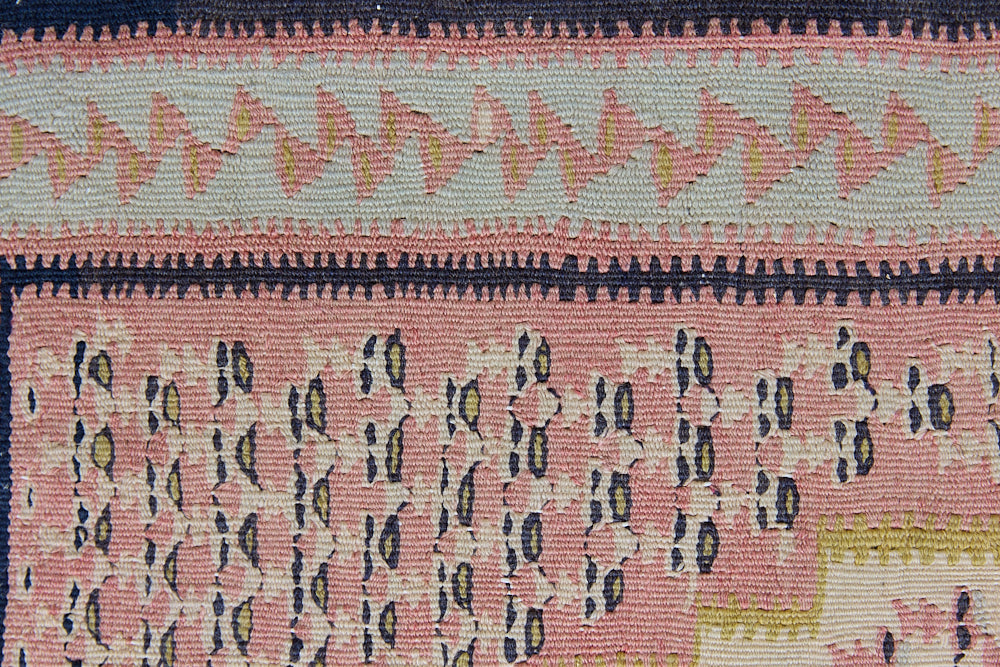 An antique Senneh kilim rug. Lale features a delicate pink and taupe central lozenge medallion on a taupe floral field with contrasting boarder.