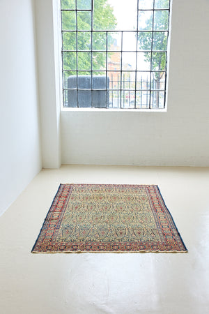 Claudette is a beautiful antique Senneh rug with an intricate design. Senneh rugs are known for their fine and intricate patterns and distinctive weaving technique. Claudette has an intricate botteh pattern and a pleasing colour palette of yellow, muted red and blue.