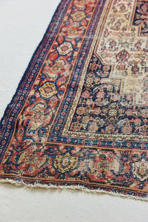 Raine is a beautiful antique Senneh rug with an intricate design. Senneh rugs are known for their fine and intricate patterns and distinctive weaving technique. Raine has a central motif surrounded by an intricate pattern and a pleasing colour palette of blue, red and taupe.
