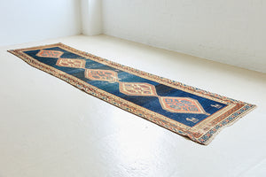 Seraphine is a beautiful antique Oushak runner with a peachy pink repeating pattern on a dark blue ground. Oushak rugs are among the most celebrated of all Turkish weavings, prized for their soft, luminous palettes and characteristically open, large-scale designs
