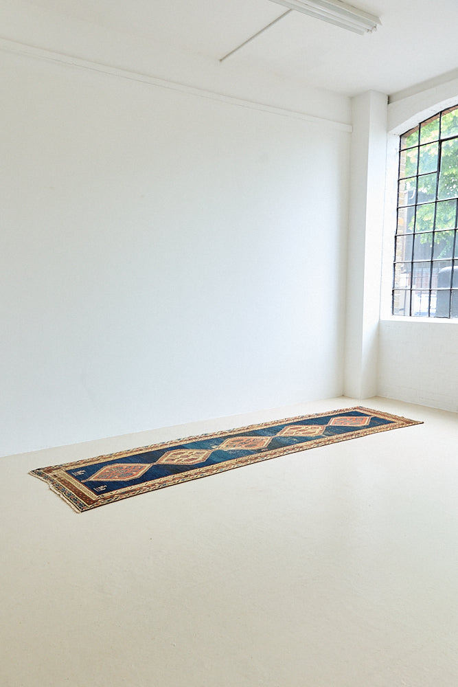 Seraphine is a beautiful antique Oushak runner with a peachy pink repeating pattern on a dark blue ground. Oushak rugs are among the most celebrated of all Turkish weavings, prized for their soft, luminous palettes and characteristically open, large-scale designs