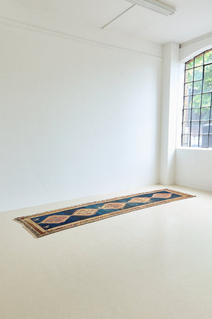 Seraphine is a beautiful antique Oushak runner with a peachy pink repeating pattern on a dark blue ground. Oushak rugs are among the most celebrated of all Turkish weavings, prized for their soft, luminous palettes and characteristically open, large-scale designs