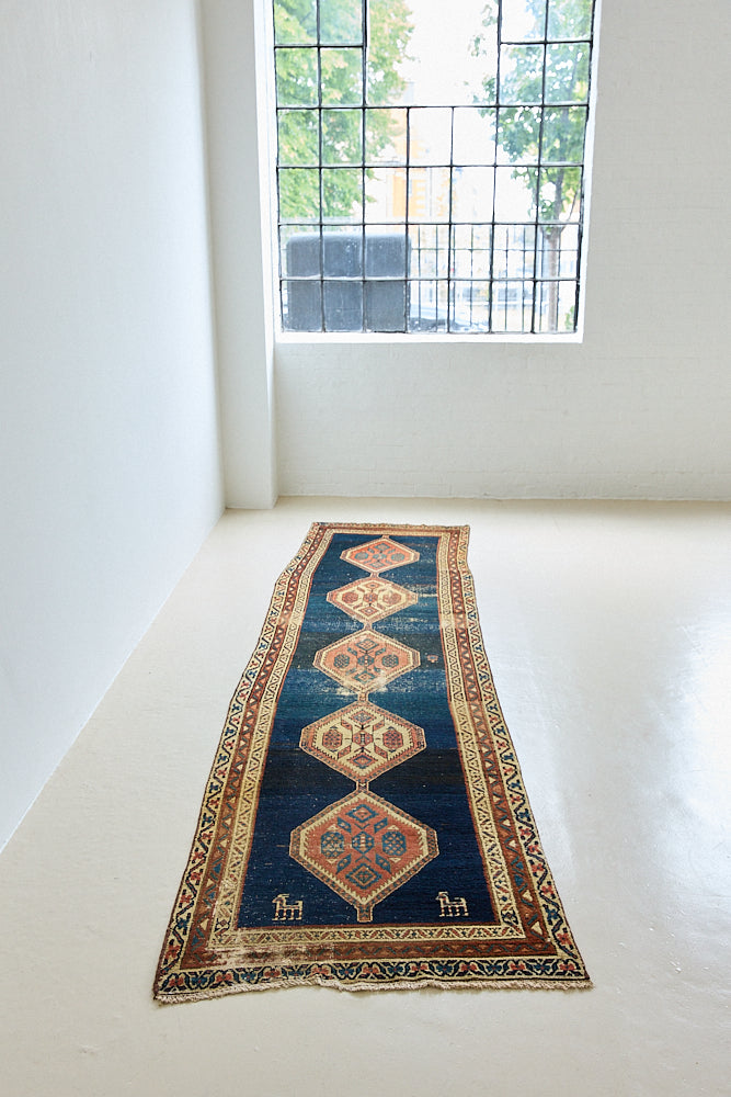 Seraphine is a beautiful antique Oushak runner with a peachy pink repeating pattern on a dark blue ground. Oushak rugs are among the most celebrated of all Turkish weavings, prized for their soft, luminous palettes and characteristically open, large-scale designs