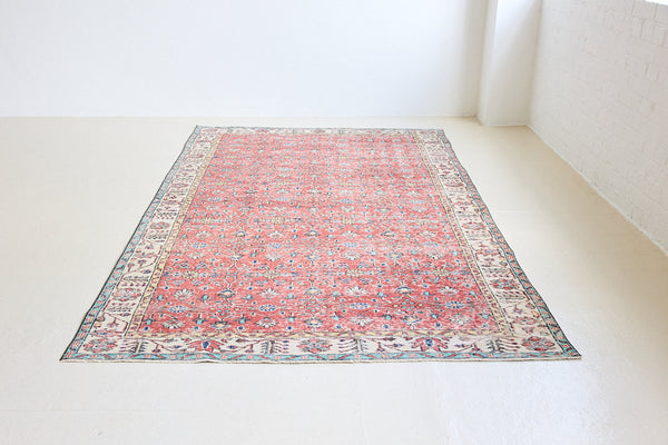 Glenda is a vintage wool rug handwoven in Turkey approximately 80 years ago. The warm terracotta field and is decorated with an all floral scrolls pattern framed by a contrasting taupe boarder.
