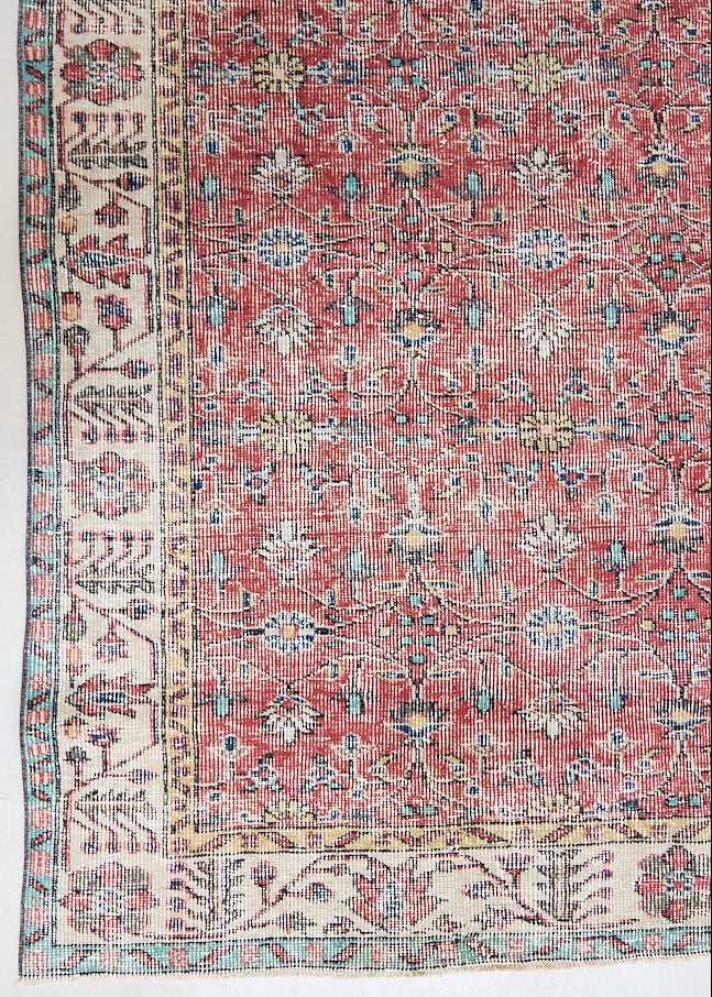 Glenda is a vintage wool rug handwoven in Turkey approximately 80 years ago. The warm terracotta field and is decorated with an all floral scrolls pattern framed by a contrasting taupe boarder.