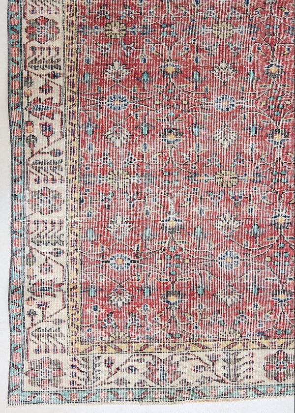 Glenda is a vintage wool rug handwoven in Turkey approximately 80 years ago. The warm terracotta field and is decorated with an all floral scrolls pattern framed by a contrasting taupe boarder.