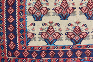 Isolde is a vintage geometric Anatolian kilim rug. Hand-woven on village and nomadic looms in vivid, naturally dyed colours, a tradition stretching back thousands of years. Kilims were woven for the practicalities of daily life and used as floor and wall coverings, storage bags, and prayer mats. Isolde features a pretty pink floral motif across a taupe field with a contrasting dark blue boarder.