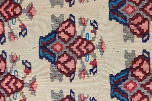 Isolde is a vintage geometric Anatolian kilim rug. Hand-woven on village and nomadic looms in vivid, naturally dyed colours, a tradition stretching back thousands of years. Kilims were woven for the practicalities of daily life and used as floor and wall coverings, storage bags, and prayer mats. Isolde features a pretty pink floral motif across a taupe field with a contrasting dark blue boarder.