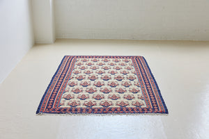 Isolde is a vintage geometric Anatolian kilim rug. Hand-woven on village and nomadic looms in vivid, naturally dyed colours, a tradition stretching back thousands of years. Kilims were woven for the practicalities of daily life and used as floor and wall coverings, storage bags, and prayer mats. Isolde features a pretty pink floral motif across a taupe field with a contrasting dark blue boarder.