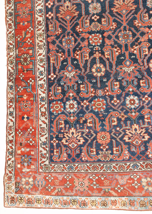 This is a Persian Mahal carpet which are known for decorative designs and repeating floral patterns. This Vintage hand woven rug features a midnight navy ground complimented by a rich red border.