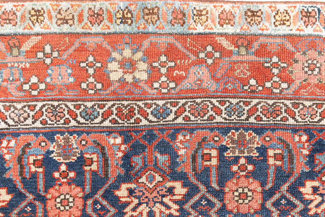 This is a Persian Mahal carpet which are known for decorative designs and repeating floral patterns. This Vintage hand woven rug features a midnight navy ground complimented by a rich red border.