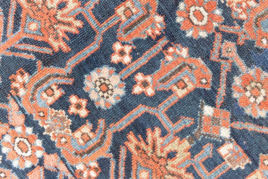 This is a Persian Mahal carpet which are known for decorative designs and repeating floral patterns. This Vintage hand woven rug features a midnight navy ground complimented by a rich red border.