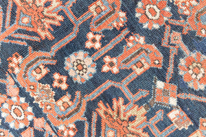 This is a Persian Mahal carpet which are known for decorative designs and repeating floral patterns. This Vintage hand woven rug features a midnight navy ground complimented by a rich red border.