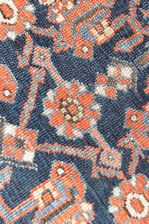 This is a Persian Mahal carpet which are known for decorative designs and repeating floral patterns. This Vintage hand woven rug features a midnight navy ground complimented by a rich red border.
