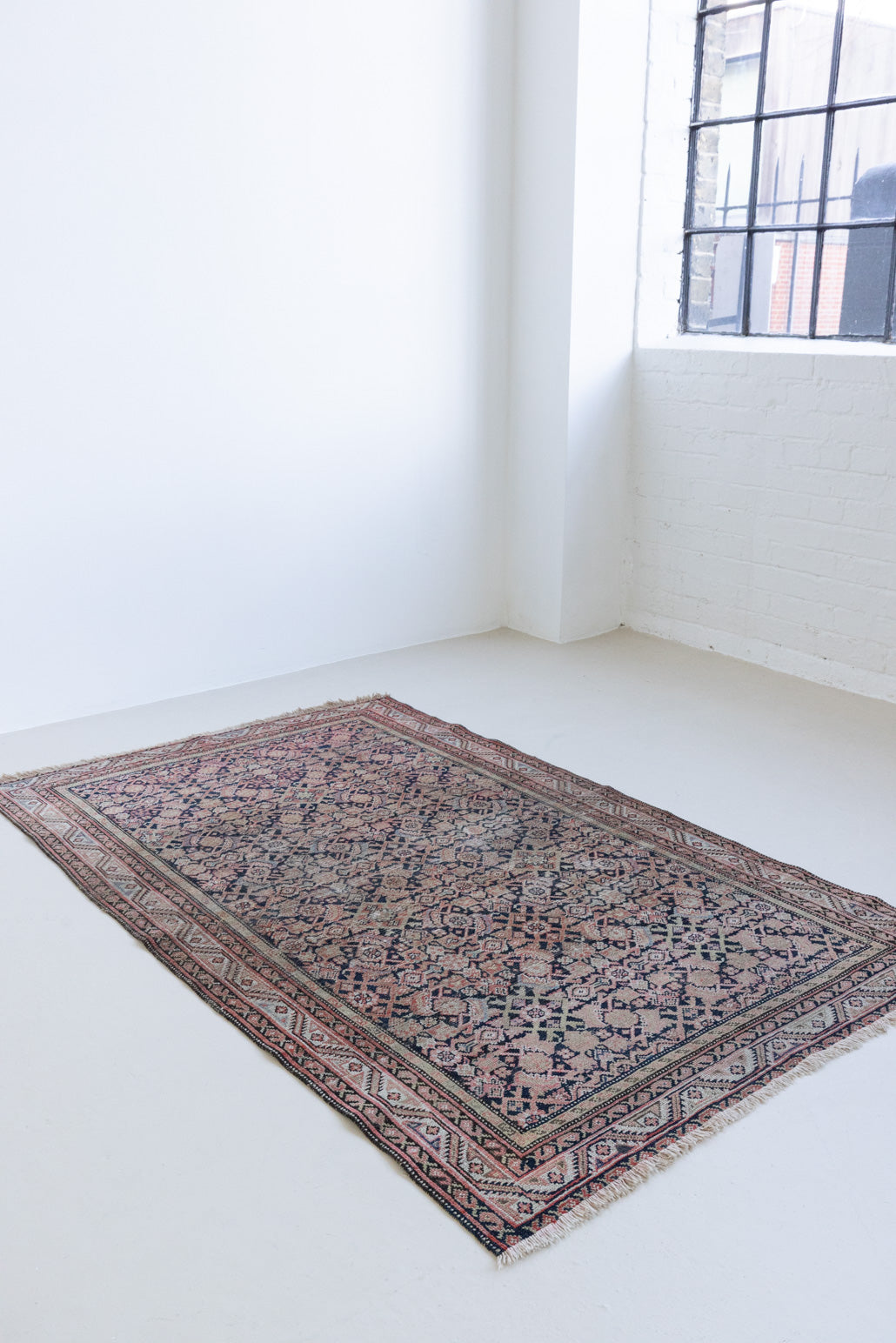 Eden is a muted pink antique Persian Malayer rug, handwoven in the North West of Iran. The Malayer region is known for ornate Persian carpets. 