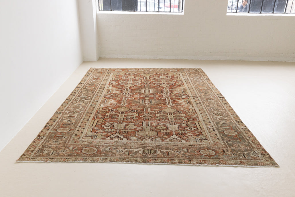 This is a antique Persian Heriz rug that has been over-dyed to gently fade its original colours, giving a more neutral palette. Persia has the most desirable rugs and carpets with stunning designs such as this carpet. Now available at Ourika London.