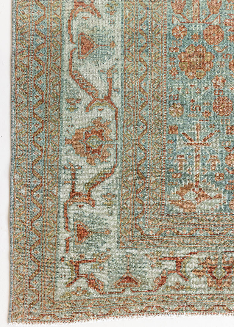 An antique Persian Malayer rug with a blue field and an earthy rust design