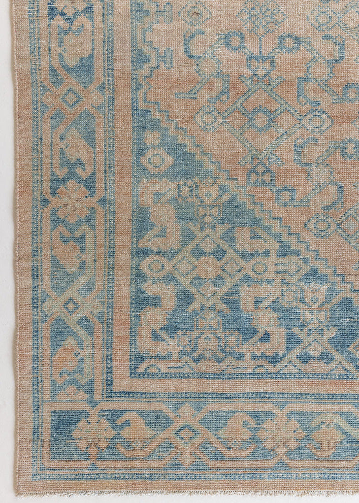An antique Persian Hamadan rug with a soft pink field and pretty blue accents