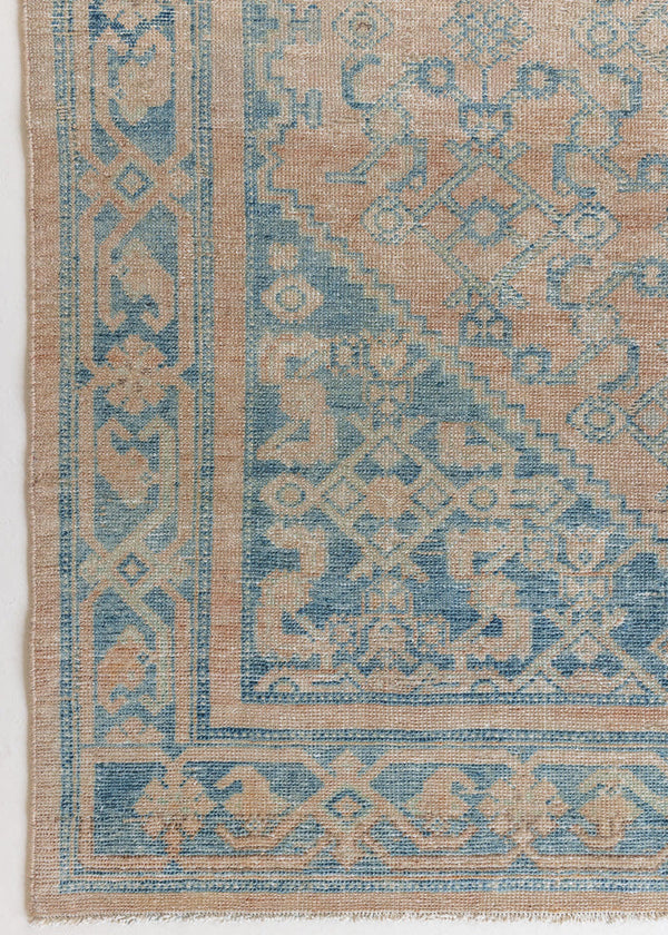 An antique Persian Hamadan rug with a soft pink field and pretty blue accents