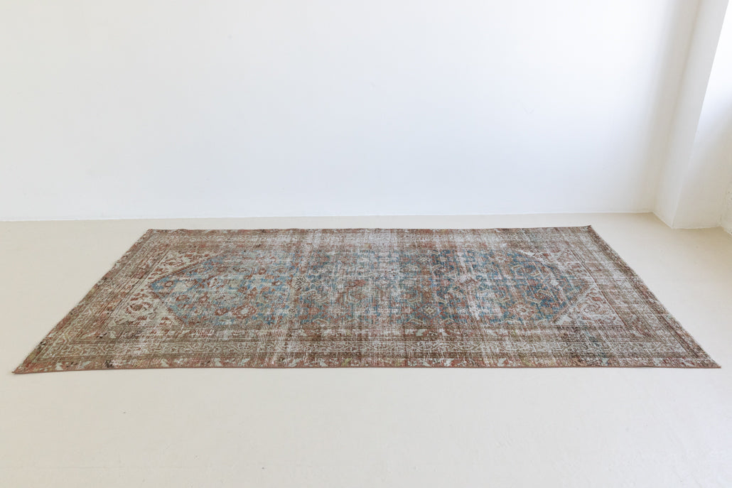 This is a antique Persian Malayer rug that has been over-dyed to gently fade its original colours, giving a more neutral palette. Persia has the most desirable rugs and carpets with stunning designs such as this carpet. Now available at Ourika London.