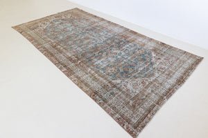 This is a antique Persian Malayer rug that has been over-dyed to gently fade its original colours, giving a more neutral palette. Persia has the most desirable rugs and carpets with stunning designs such as this carpet. Now available at Ourika London.