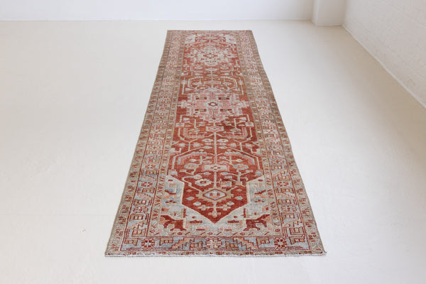 Handwoven antique Persian carpet runner with an elongated medallion design in rust and taupe