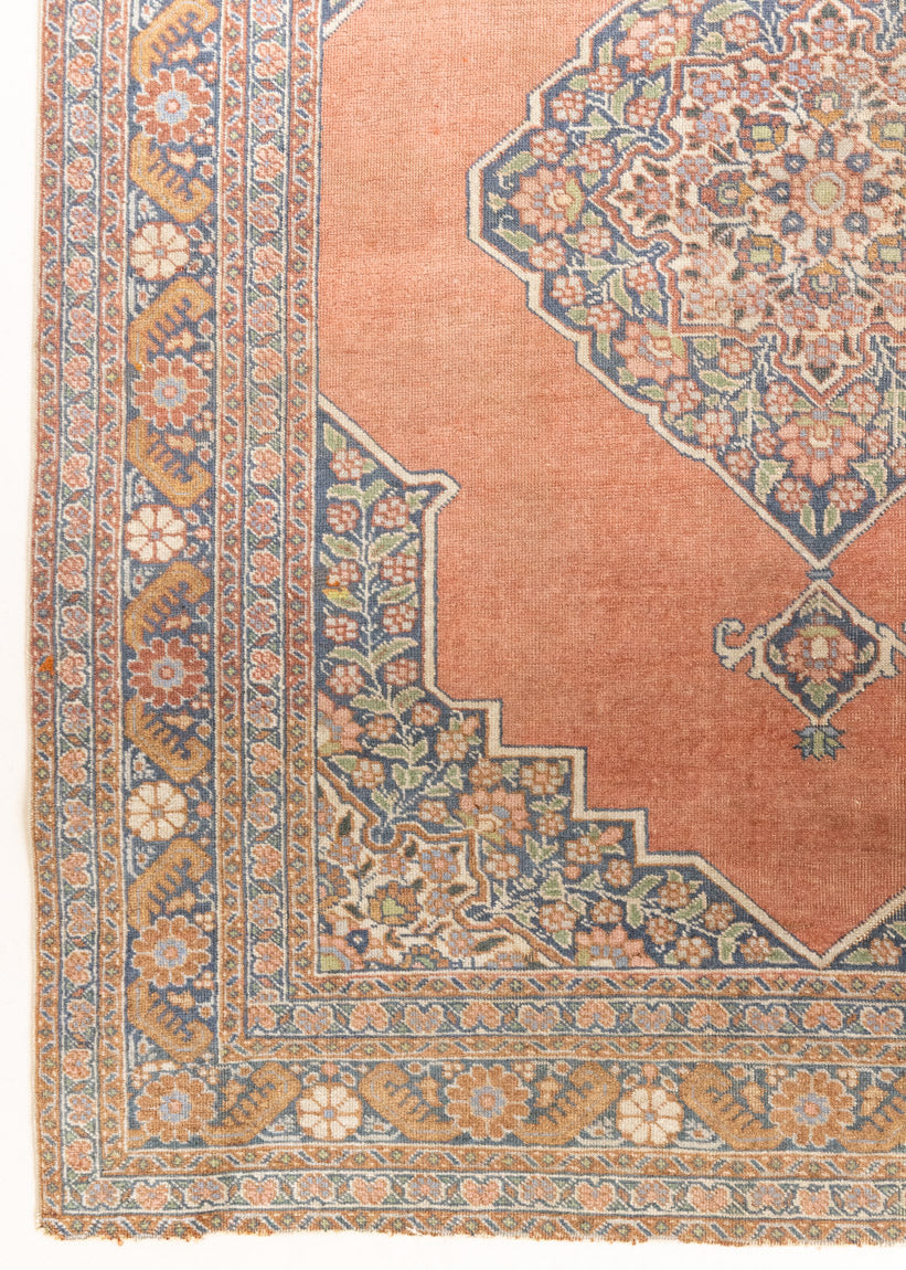 Selma is a beautiful antique Persian Tabriz rug with a soft yet bold coral colour palette and a stunning abrash and patina with a lovely central medallion within the carpet.