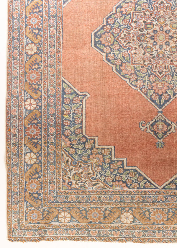 Selma is a beautiful antique Persian Tabriz rug with a soft yet bold coral colour palette and a stunning abrash and patina with a lovely central medallion within the carpet.