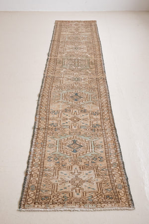 Bonnie is an vintage Persian Heriz runner rug which has been antique washed using a special technique to gently fade its original colours, creating a stunning muted palette. Heriz rugs are some of the most sought after Persian carpets and this one features a classic Heriz design in gorgeous soft blue, taupe and cream tones. 
