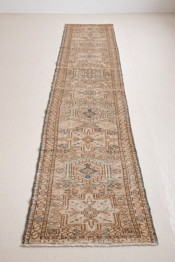 Bonnie is an vintage Persian Heriz runner rug which has been antique washed using a special technique to gently fade its original colours, creating a stunning muted palette. Heriz rugs are some of the most sought after Persian carpets and this one features a classic Heriz design in gorgeous soft blue, taupe and cream tones. 