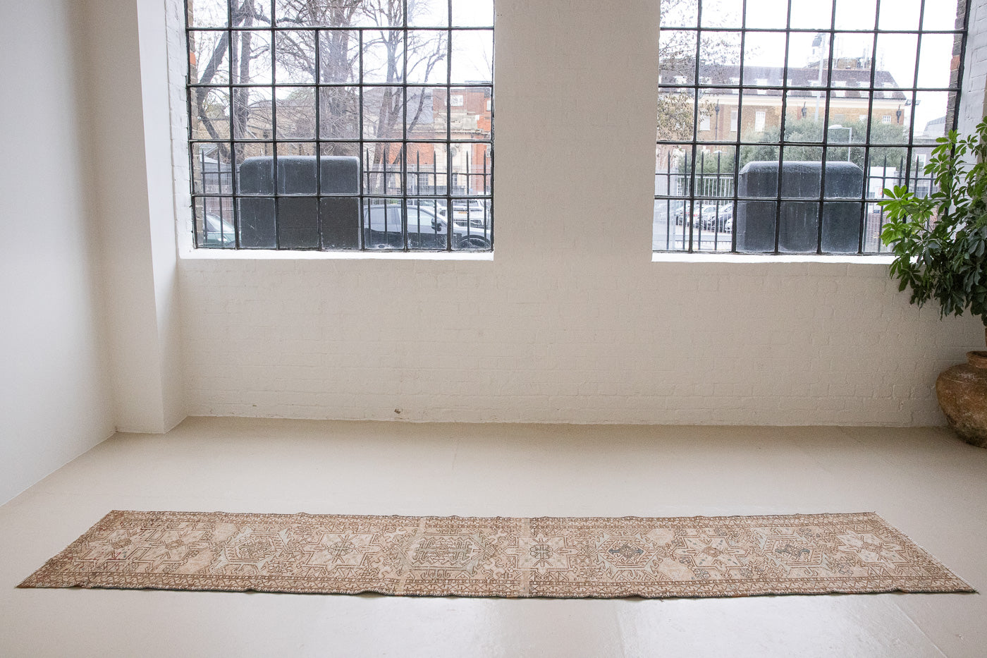 Bonnie is an vintage Persian Heriz runner rug which has been antique washed using a special technique to gently fade its original colours, creating a stunning muted palette. Heriz rugs are some of the most sought after Persian carpets and this one features a classic Heriz design in gorgeous soft blue, taupe and cream tones. 