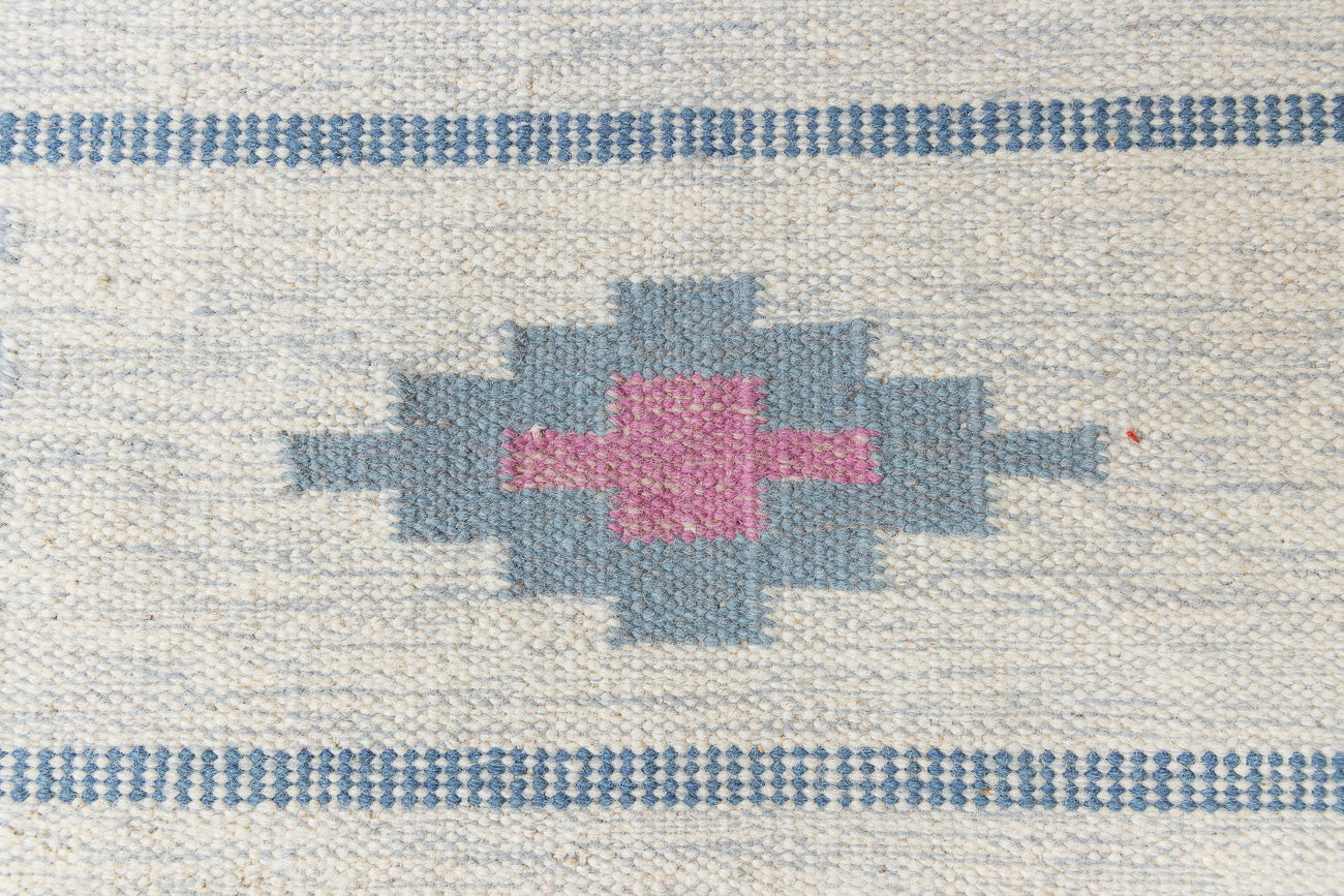 This rug shows beautiful tones of blue, this vintage kilim is featuring bold geometric design with hints of pink within the motifs in the carpet. 